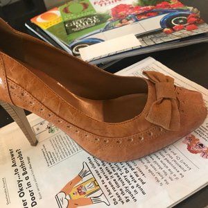 Tan patent leather shoe with suede bow